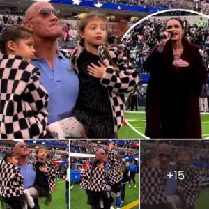 Dwayne ‘The Rock’ Johnson looks visibly emotional as he holds his two young daughters while watching wife Lauren Hashian perform the National Anthem