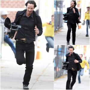 Keanu Reeves running with a camera he stole from a paparazzi