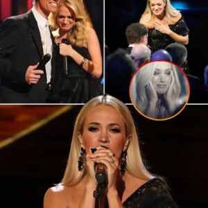 Carrie Underwood’s Tearjerking Tribute to Randy Travis Had Everyone Crying. The energy in the room shifted the second Carrie Underwood took the stage at the Opry 100 celebration. Dressed in an elegant black gown—just like the one she wore 17 years ago when Randy Travis changed her life—she was about to return the favor. Three years after her American Idol win, she was already a superstar, but nothing could have prepared her for what happened next. Mid-performance, the crowd erupted, standing in unison. Confused, she turned—and there he was. Randy Travis, in the flesh, stepping onto the stage behind her. The shock on her face said it all. This was a full-circle moment like no other. Carrie poured her heart into two of his greatest hits, starting with Three Wooden Crosses, and as her voice filled the room, the cameras panned to the audience—eyes glistening, hands clutching chests. Even Randy’s wife, Mary Davis, couldn’t hold back the tears. By the time she finished, the entire crowd was on their feet, giving a standing ovation not just to her, but to the legend himself.