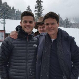 A moment that melted every heart. As the lights dimmed and the music stopped, Donny Osmond took his son Chris’s hand — and in that instant, chaos turned into magic. Their voices joined as one, filling the air with love and emotion. Draper Days had never seen anything like it — a performance born from family, faith, and pure feeling. When the final note ended, the crowd stood, cheering through tears. A memory that will never fade.